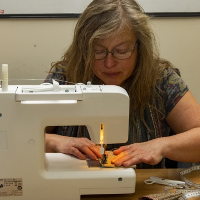 A lady using a sewing machine